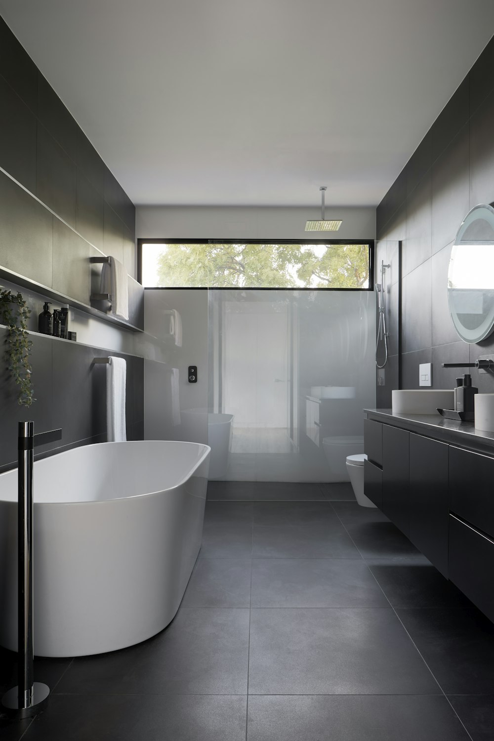 Large-format tiled bathroom with floor-to-floor porcelain walls and floor by S&J Ceramic Tiling